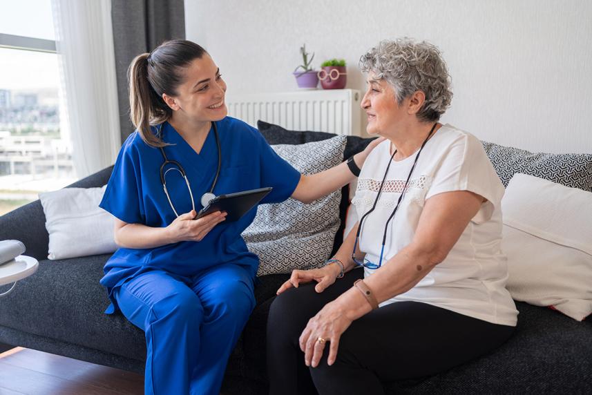 Healthcare worker and patient sitting on sofa